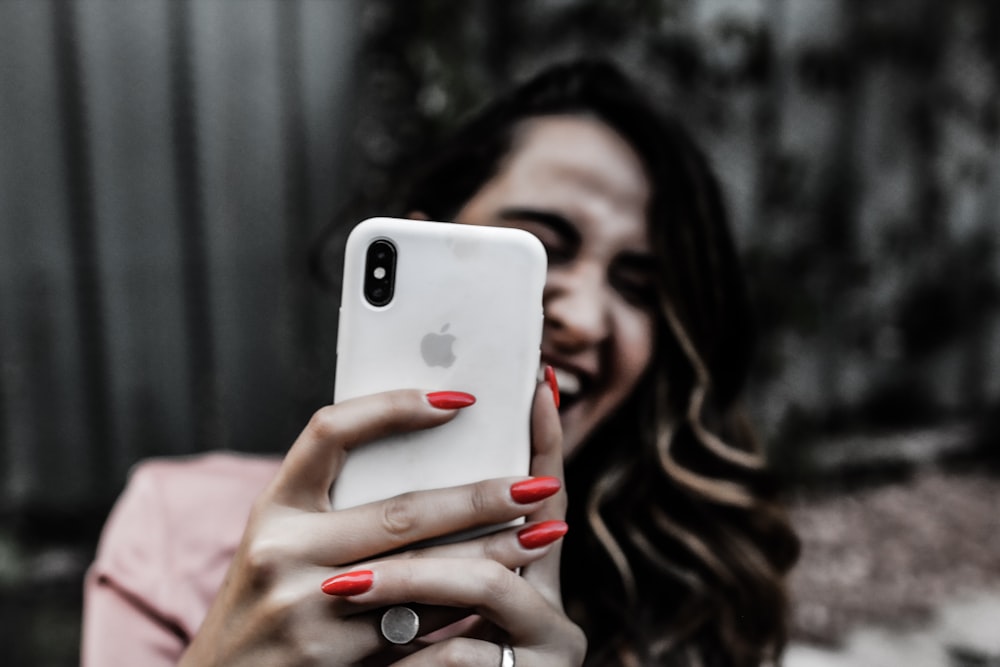 a woman smiles while holding a cell phone
