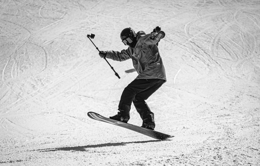 a man riding a snowboard down a snow covered slope