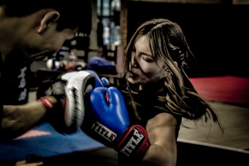 a man and a woman boxing in a gym