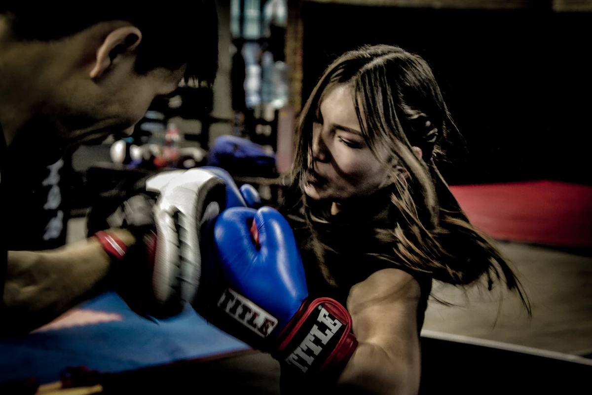 A man and a woman boxing together in a gym