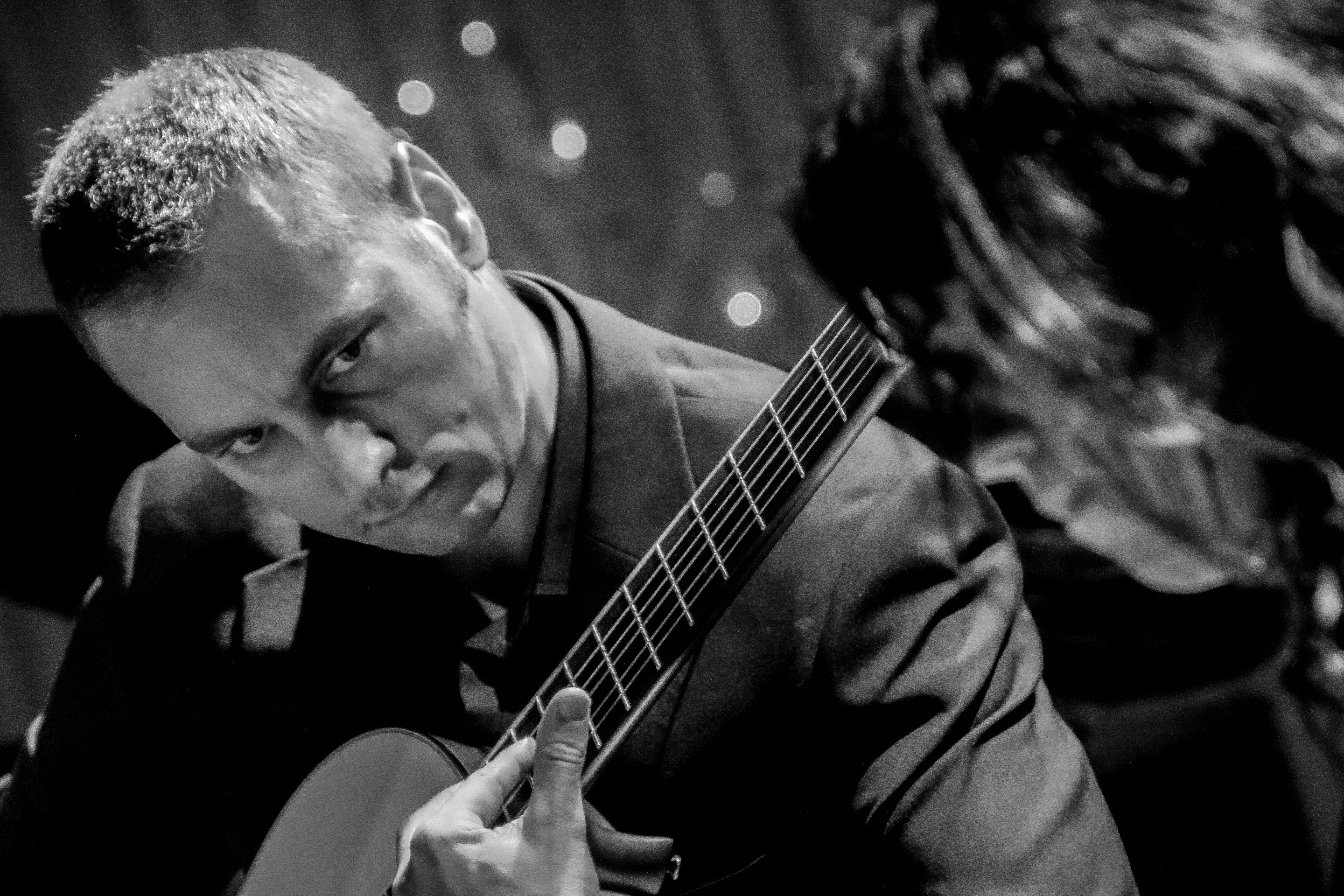 a man playing a guitar next to a woman