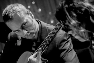 a man playing a guitar next to a woman