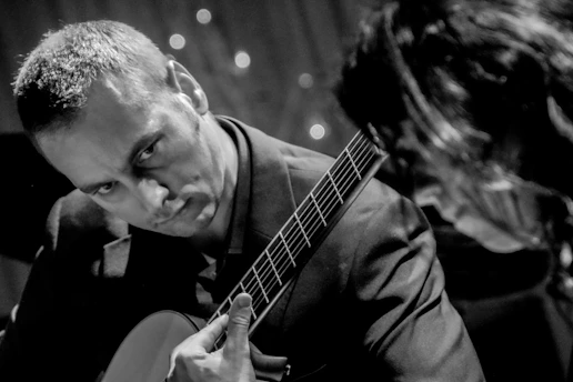 a man playing a guitar next to a woman
