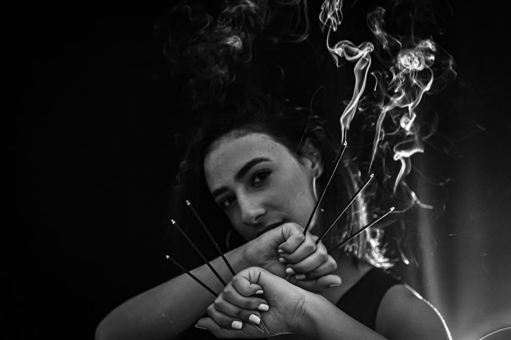 a woman holding a cigarette in front of her face