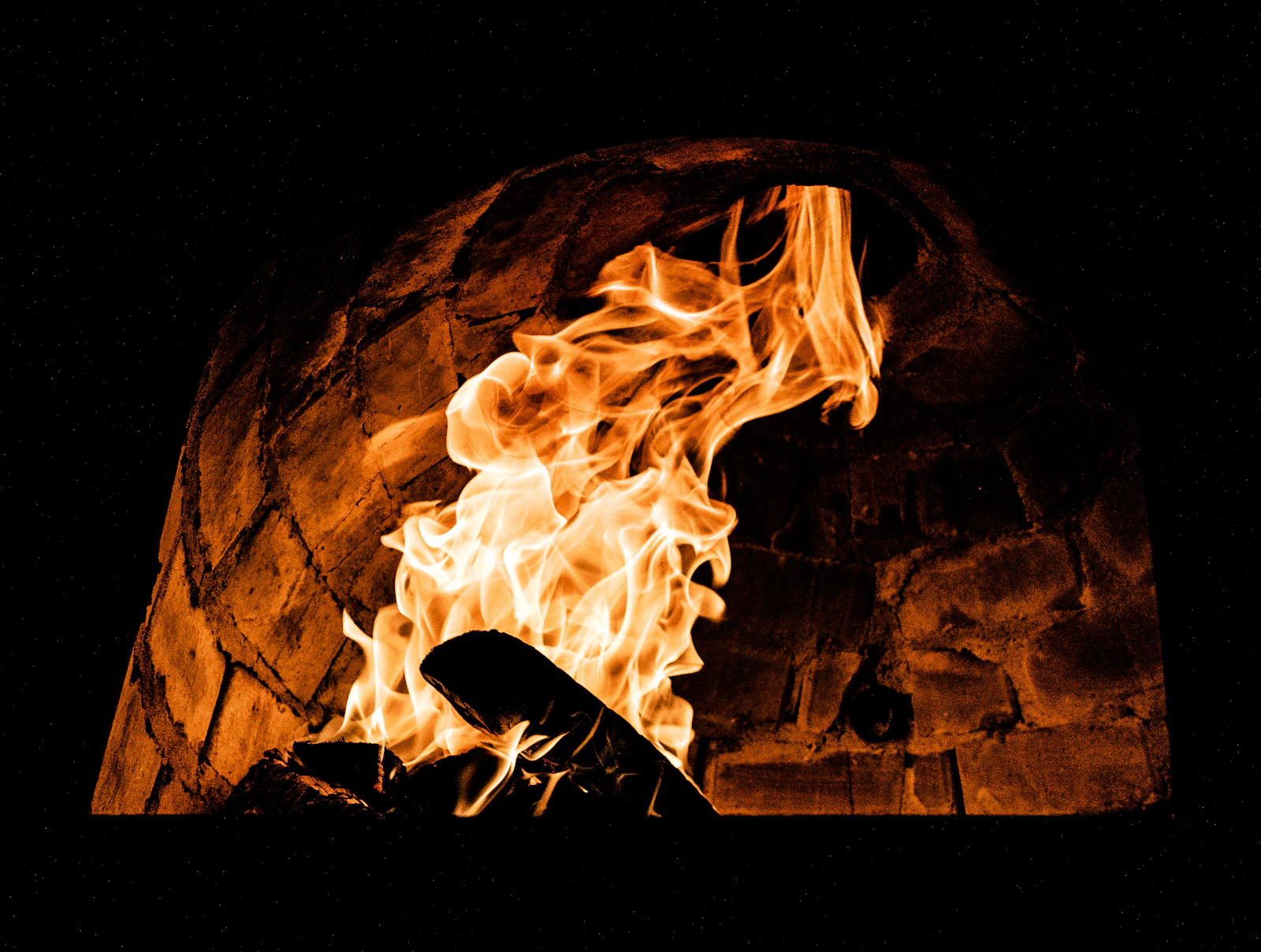 Oak flames rolling through the brick hearth, lit every afternoon at four