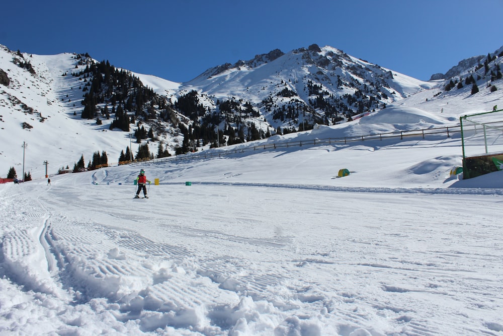 a man riding skis down a snow covered slope