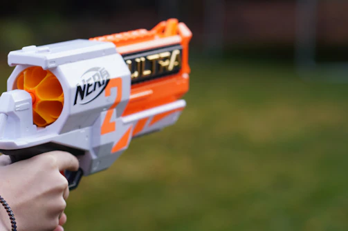 a close up of a person holding a toy gun