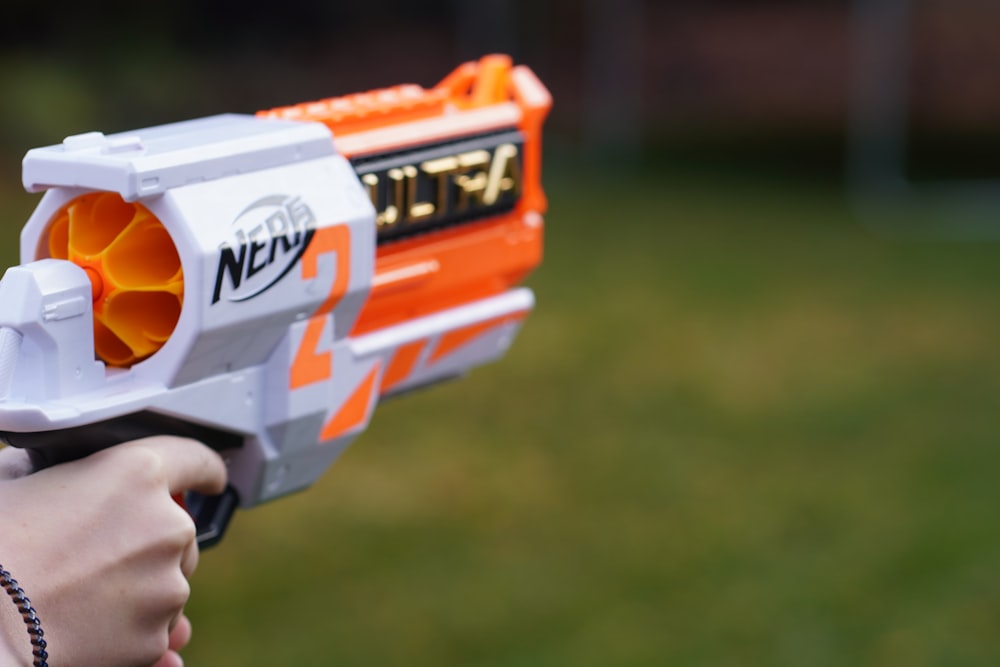 a close up of a person holding a toy gun