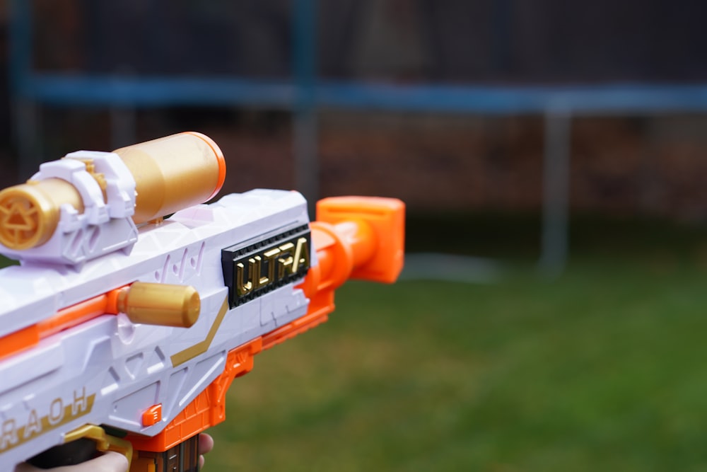 a close up of a toy gun in a person's hand