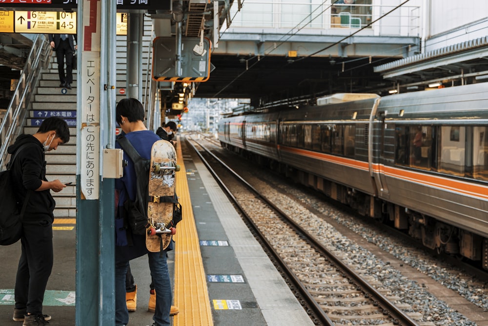 a couple of people standing next to a train