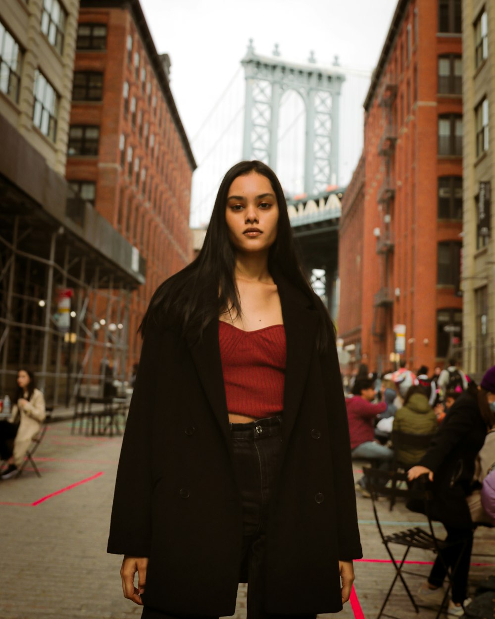 a woman in a red top and black coat