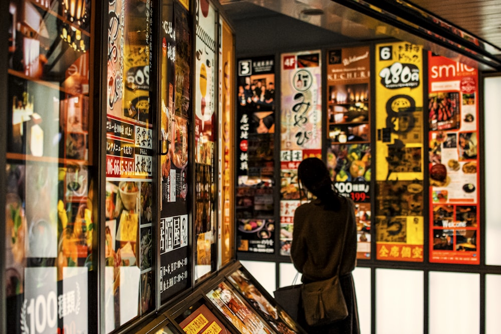 Una persona parada frente a la ventana de una tienda