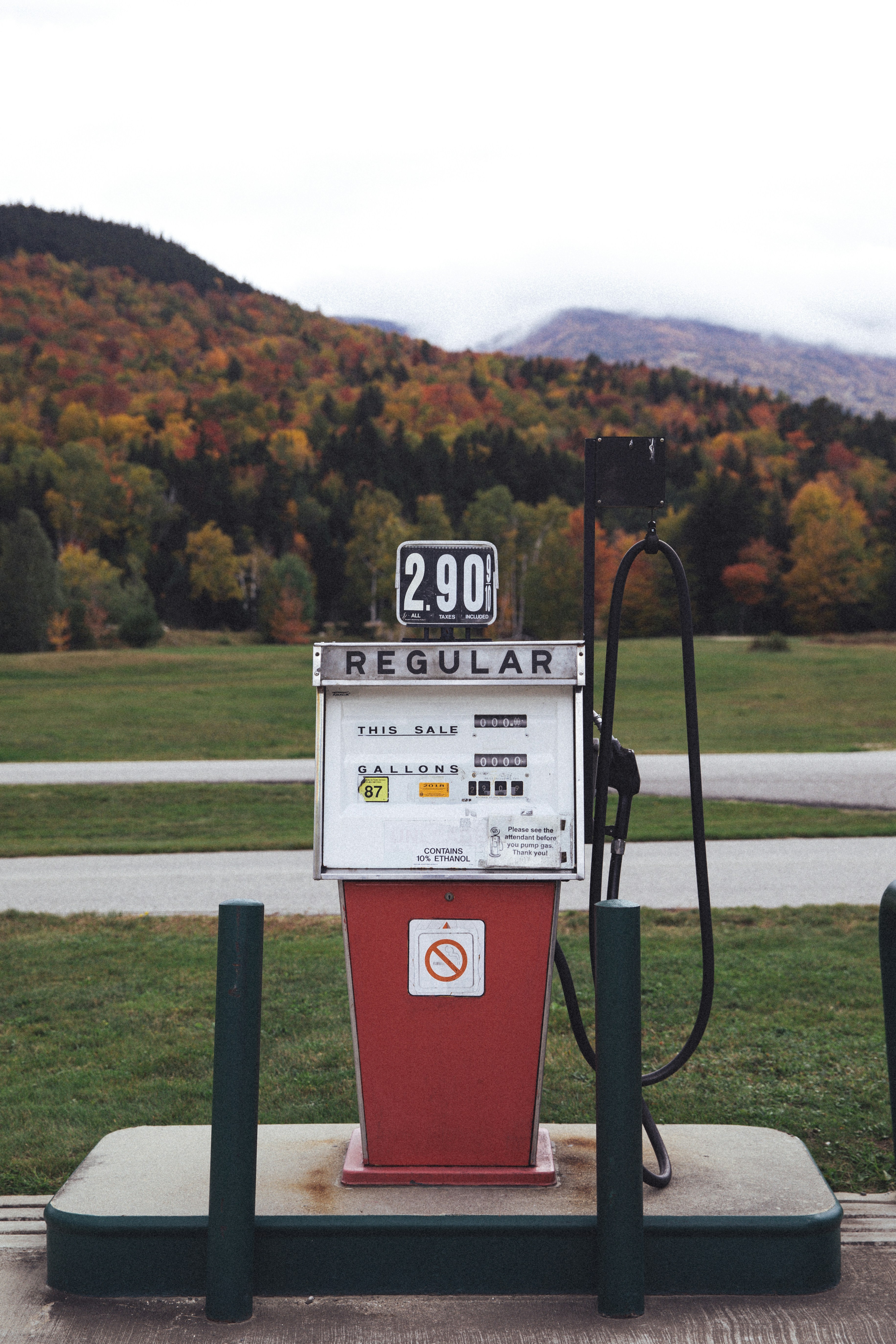 a red and white gas pump sitting on top of a field