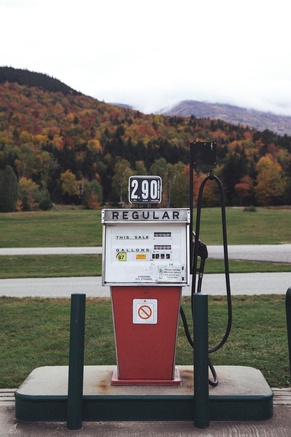 a red and white gas pump sitting on top of a field