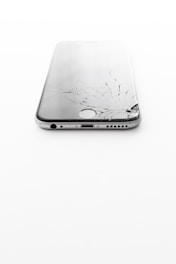 a broken cell phone sitting on top of a white table