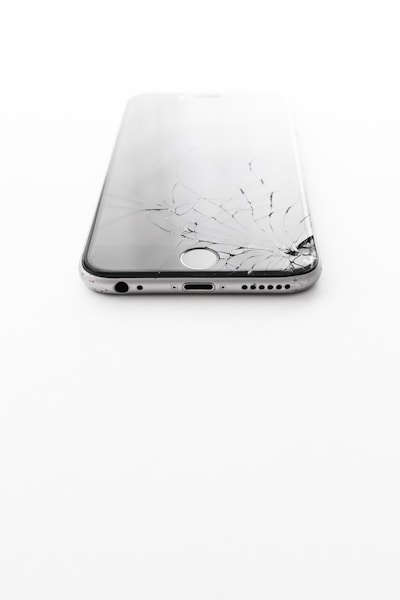 a broken cell phone sitting on top of a white table