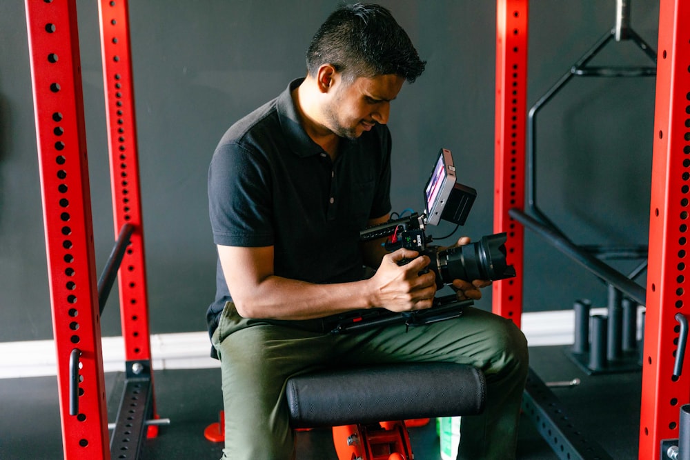 a man sitting on a bench holding a camera