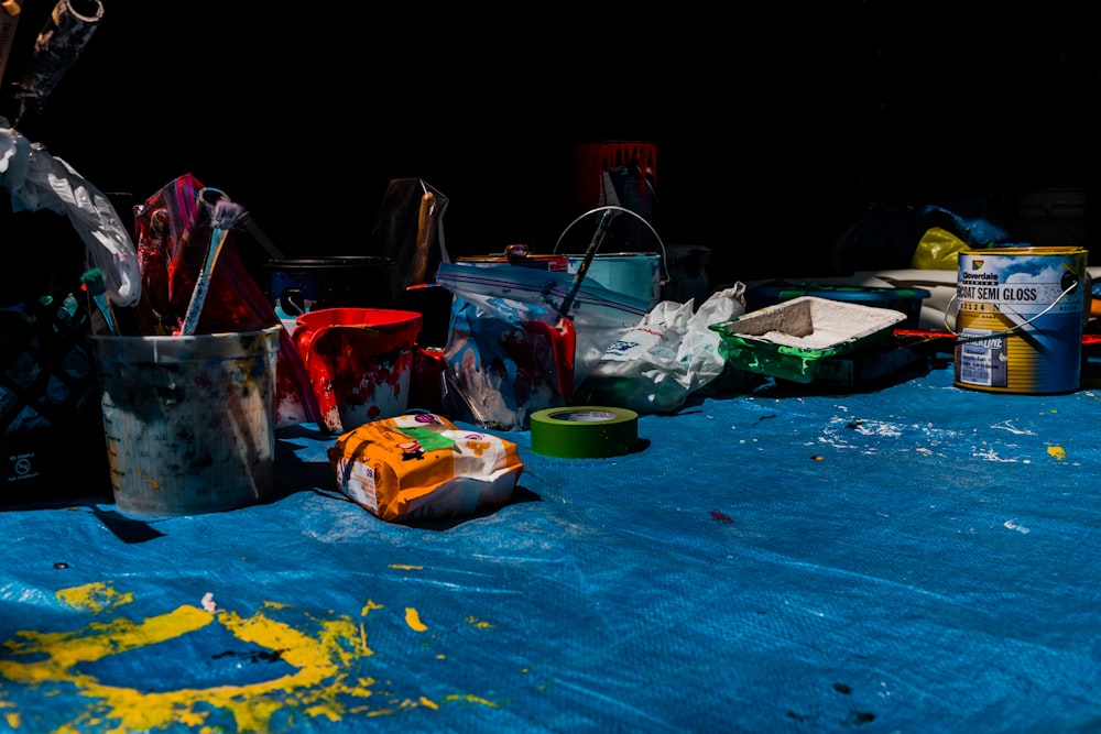 a blue table covered in lots of paint and supplies