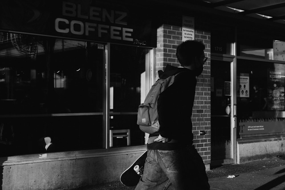 a black and white photo of a man walking down the street