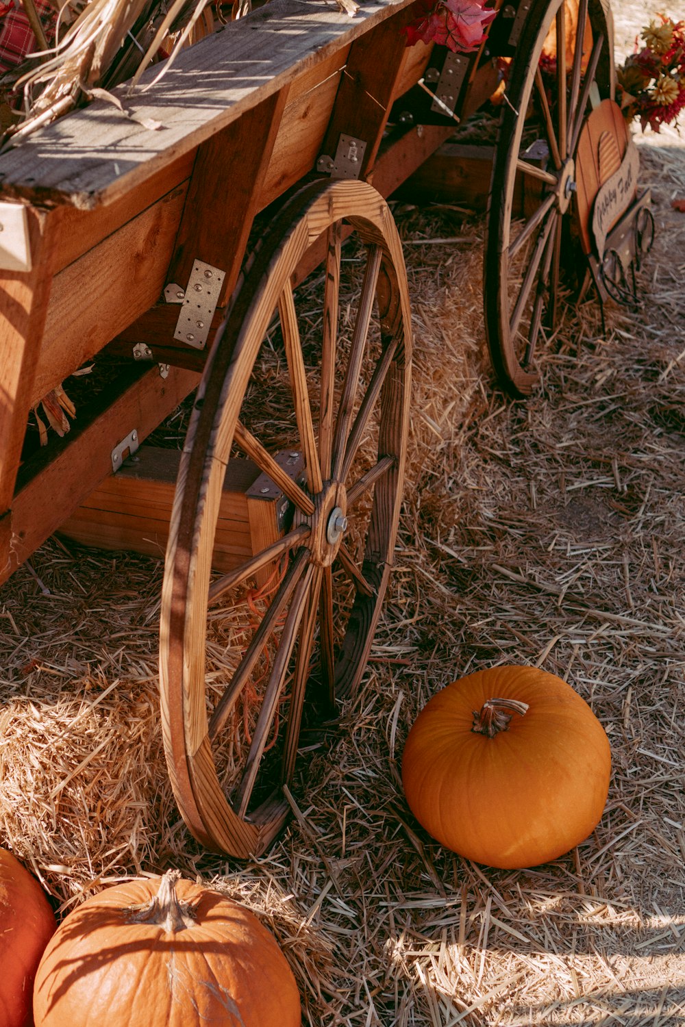 a wagon with pumpkins sitting in the hay