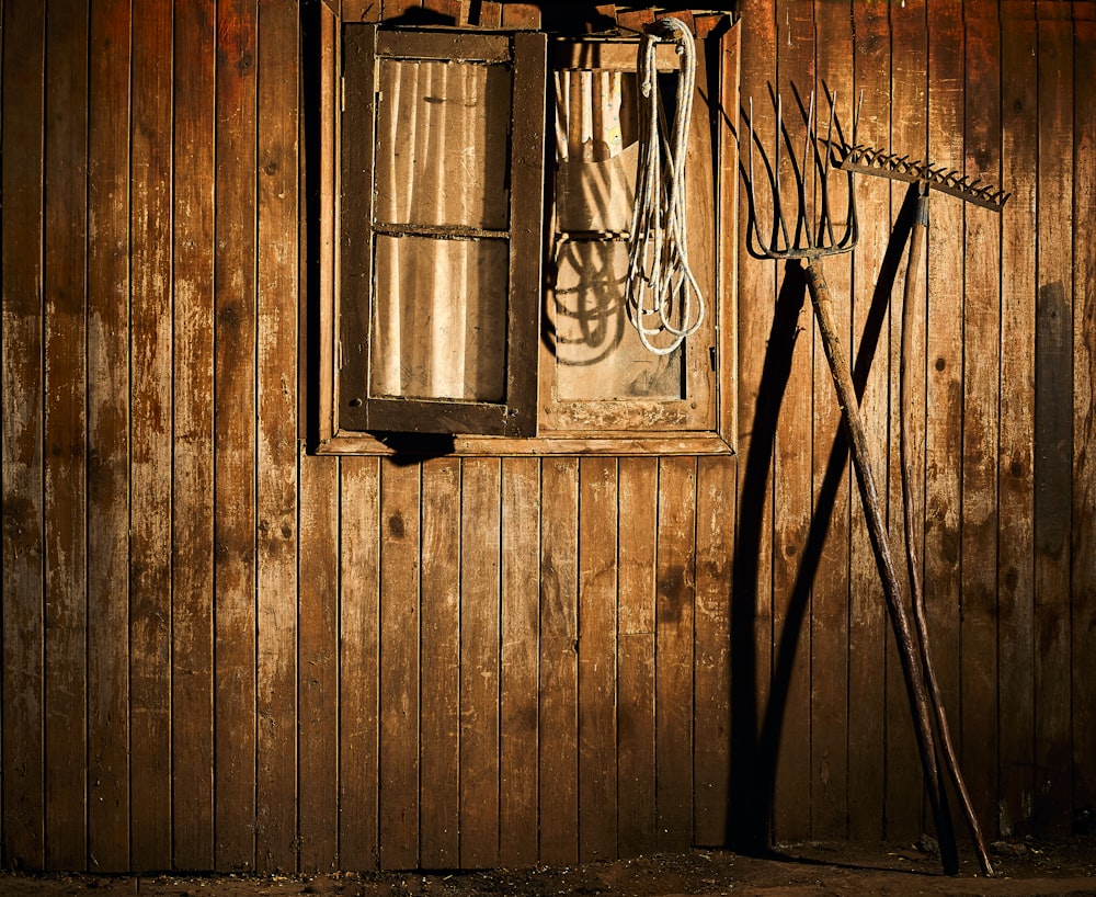 eine alte Holzwand mit einem Fenster und einer Schere