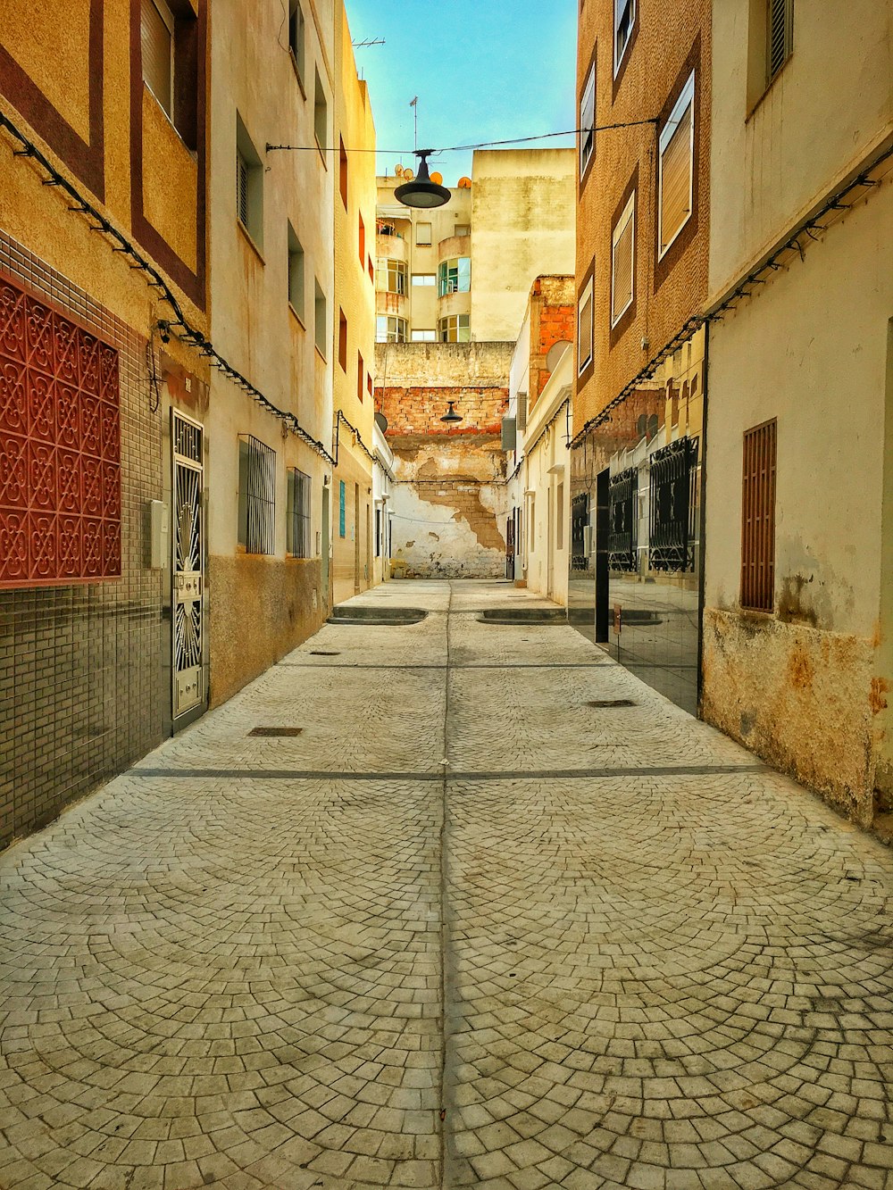 an empty street with a clock on the side of it