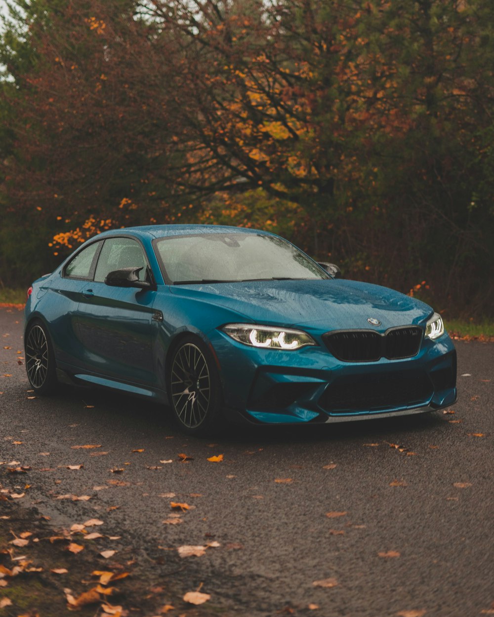 a blue car parked on the side of a road