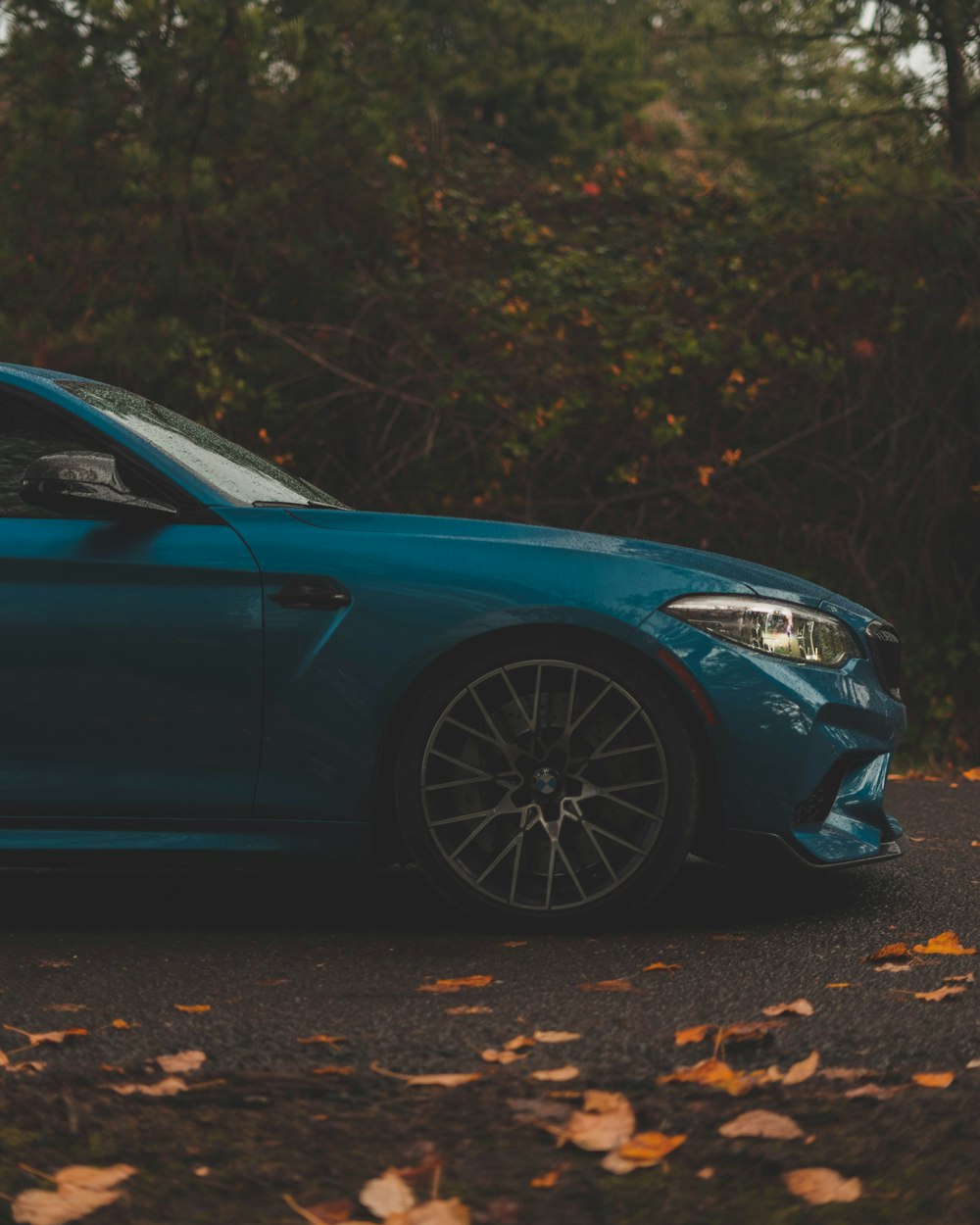 um carro azul estacionado na beira da estrada