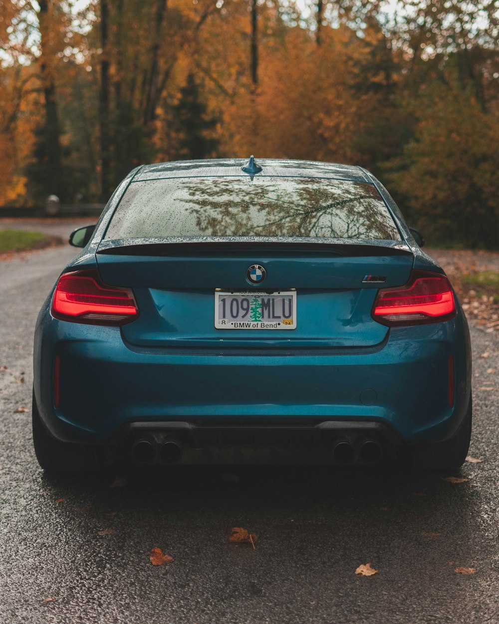 um carro azul estacionado ao lado de uma estrada