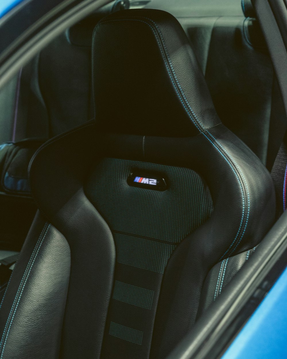 a close up of a car's seats with a blue car in the background