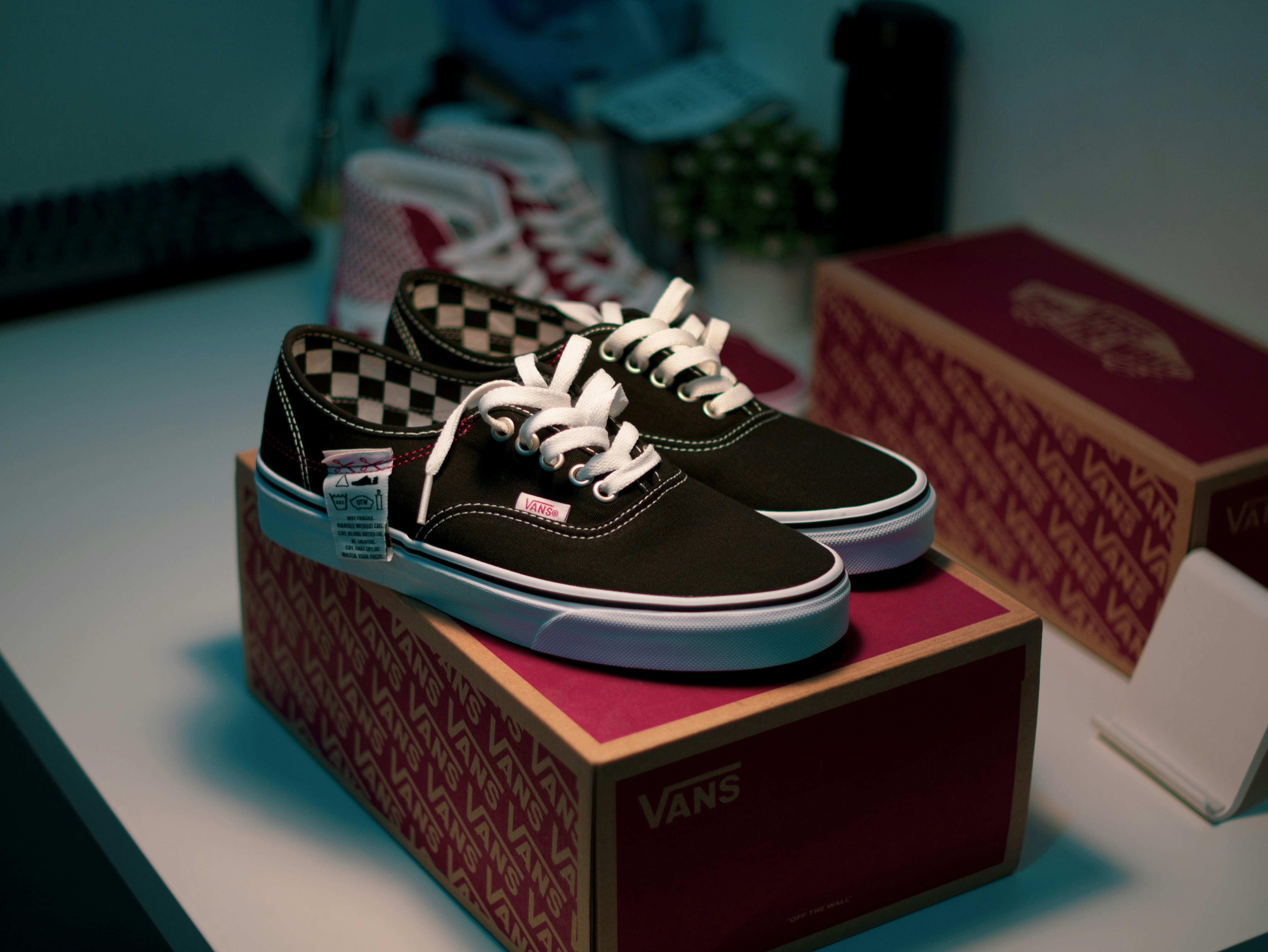 a pair of black and white vans are sitting on a box