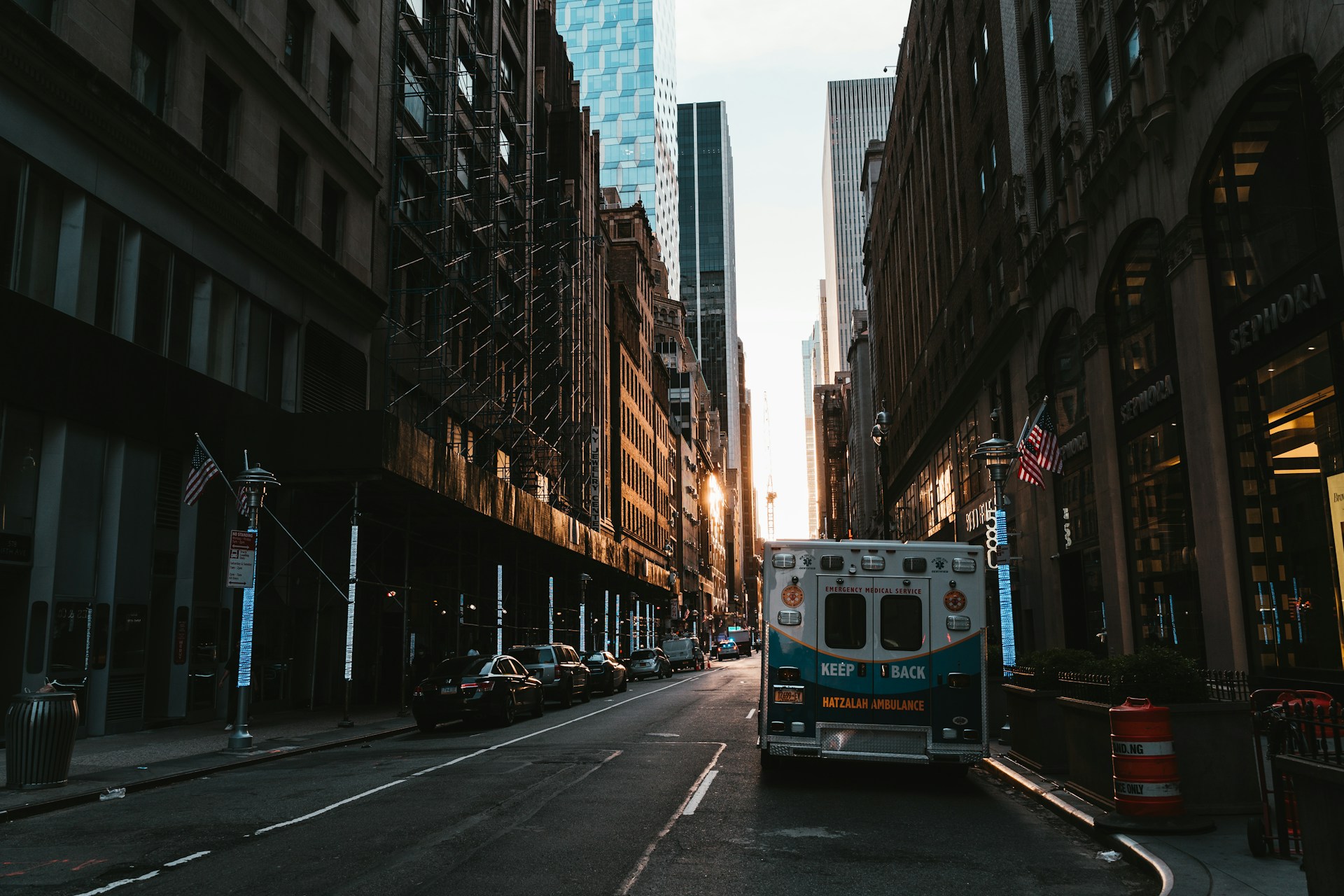 a truck driving down a street next to tall buildings