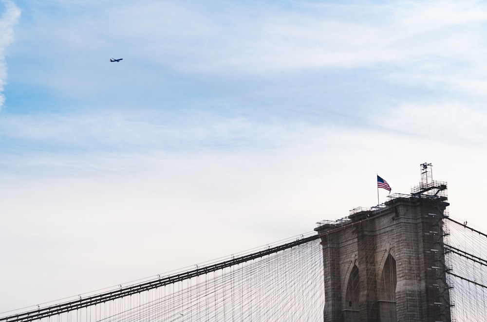 a plane flying over the top of a bridge