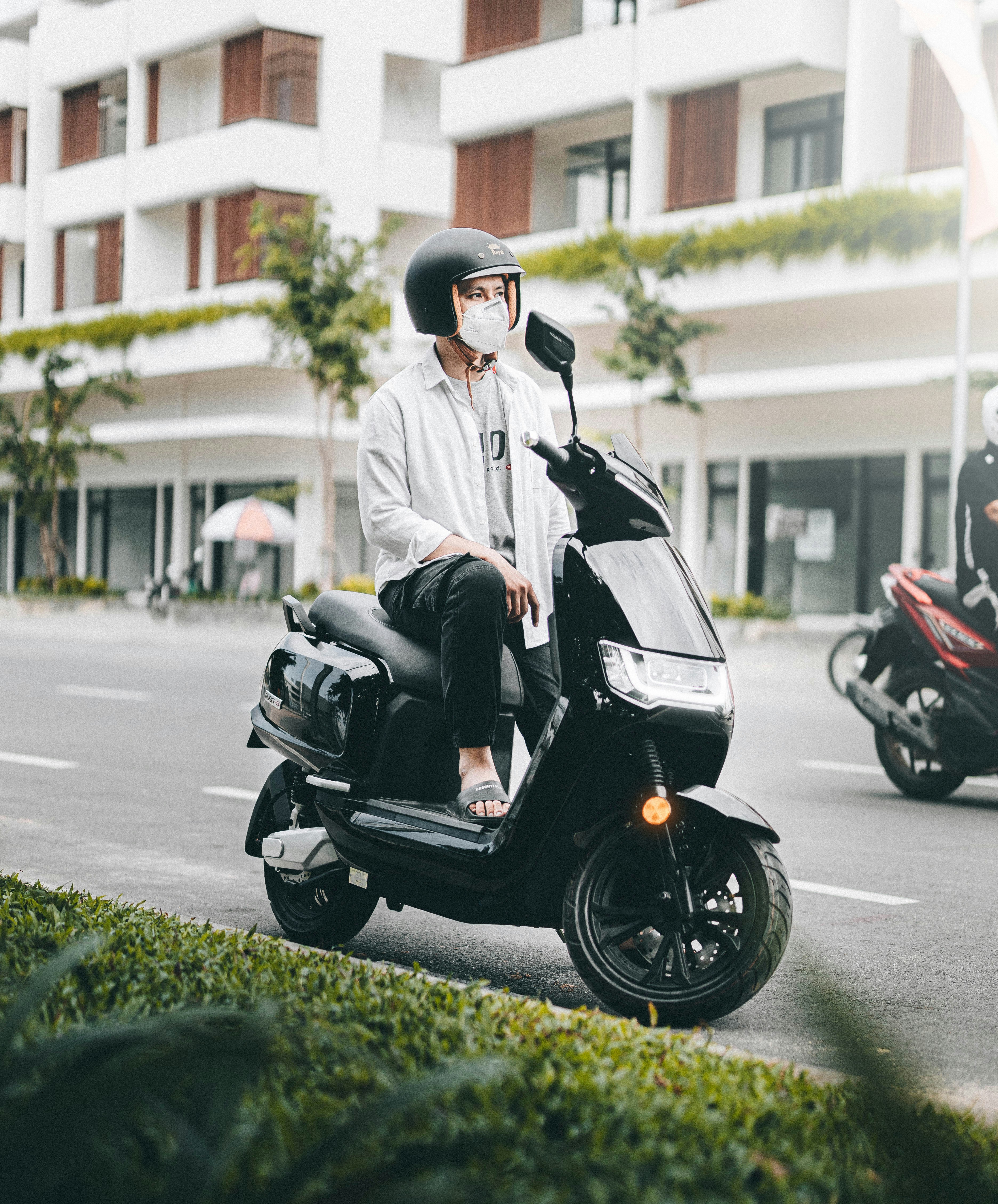 a man sitting on a scooter talking on a cell phone