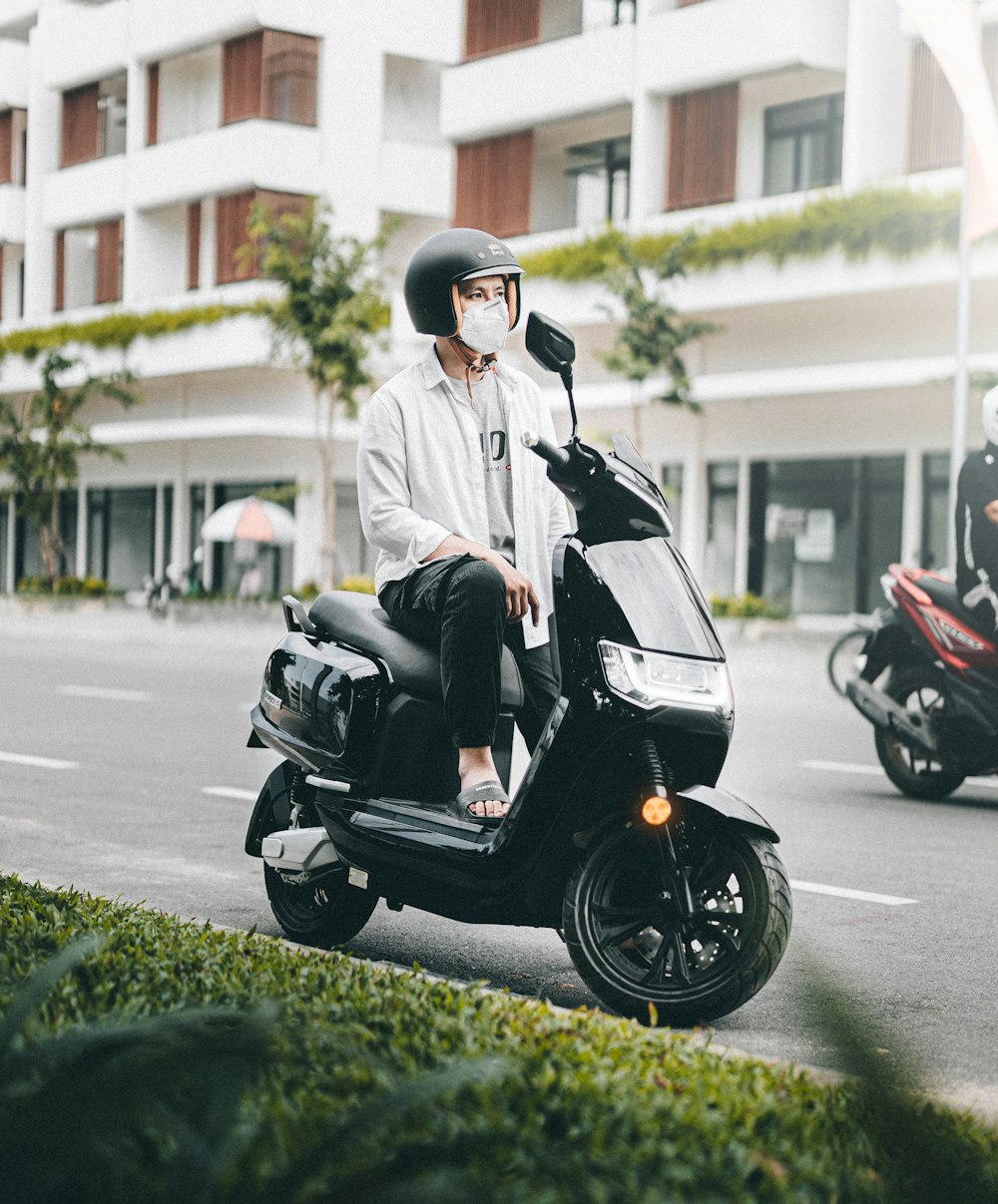 a man sitting on a scooter talking on a cell phone