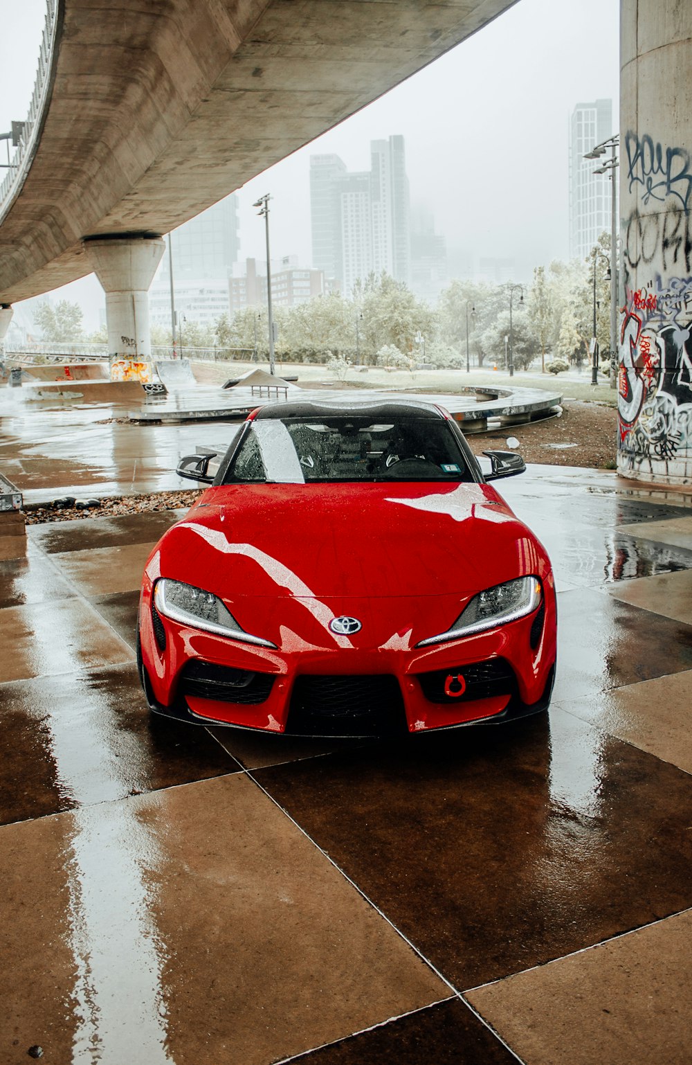 a red sports car parked under a bridge