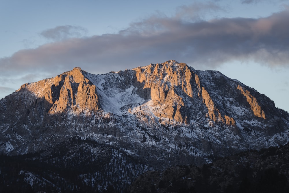 a snow covered mountain with a cloud in the sky