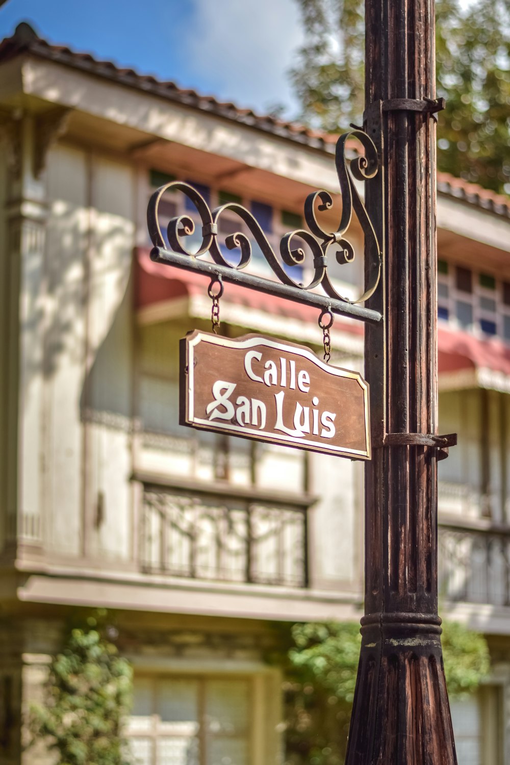 a street sign on a lamp post in front of a building