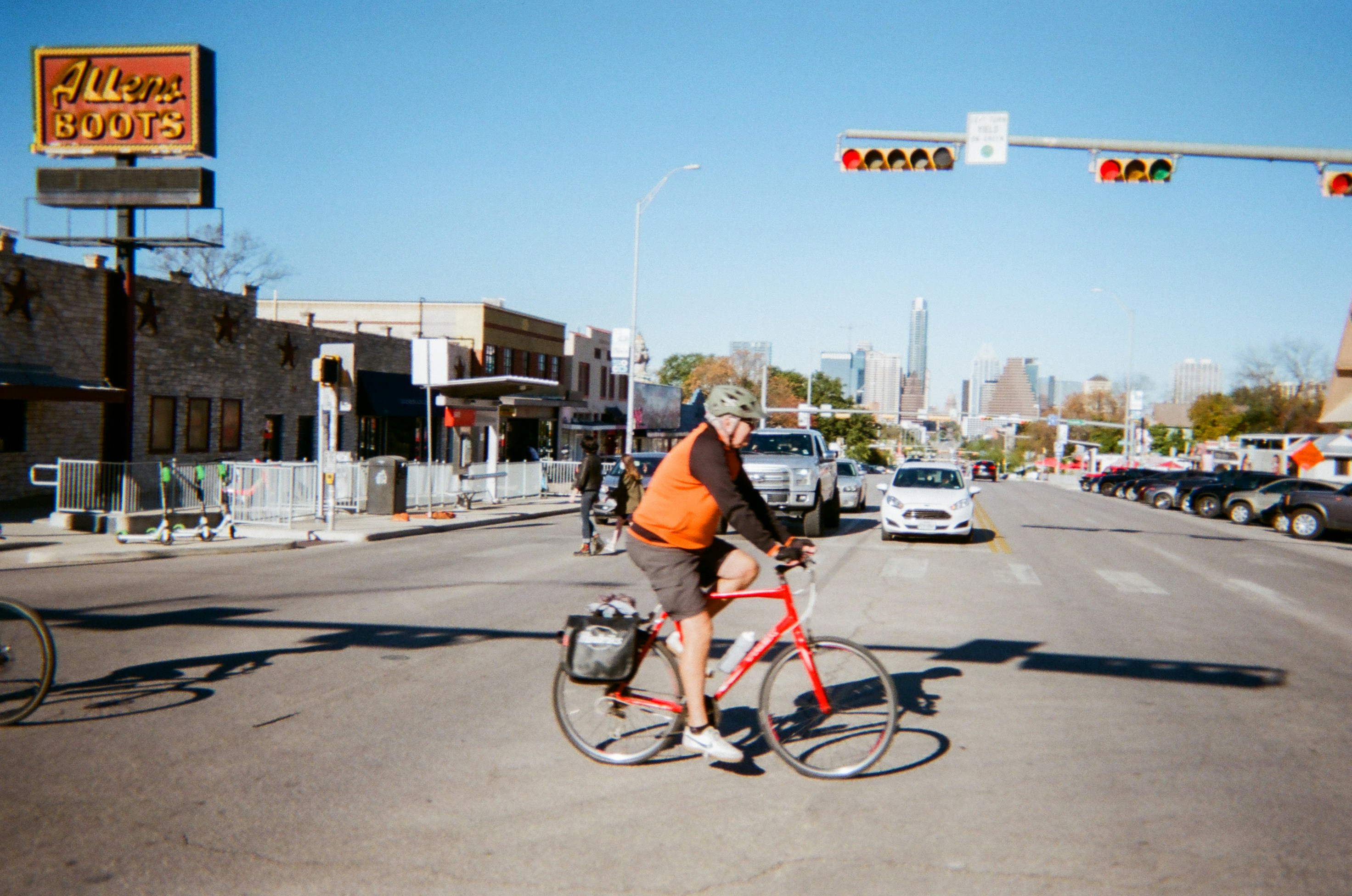 a man riding a bike down a street next to traffic lights