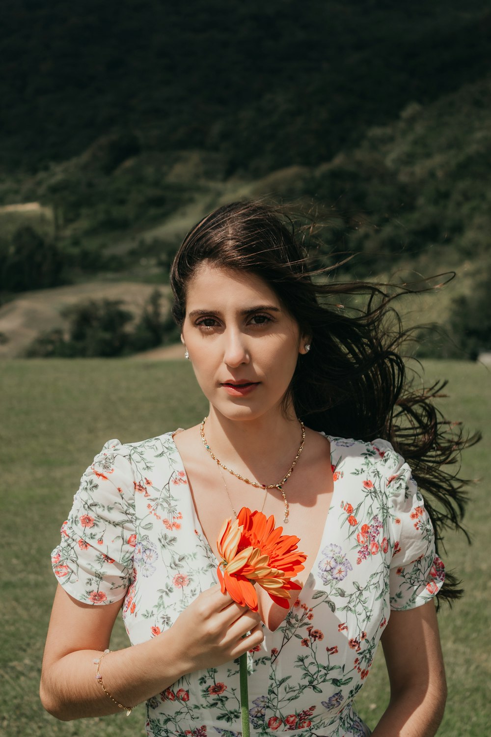 a woman holding a flower in a field