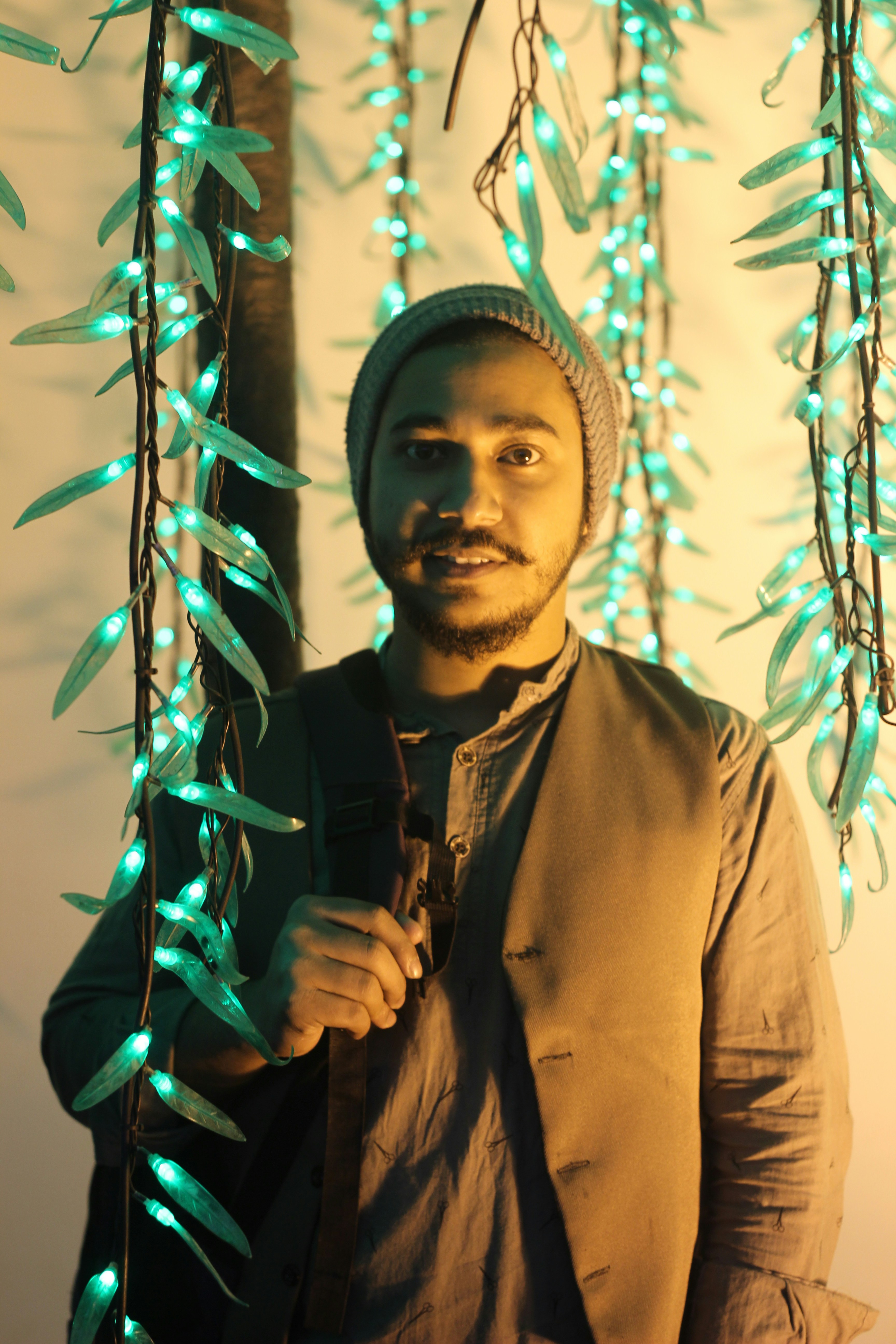 a man in a turban is holding a string of lights