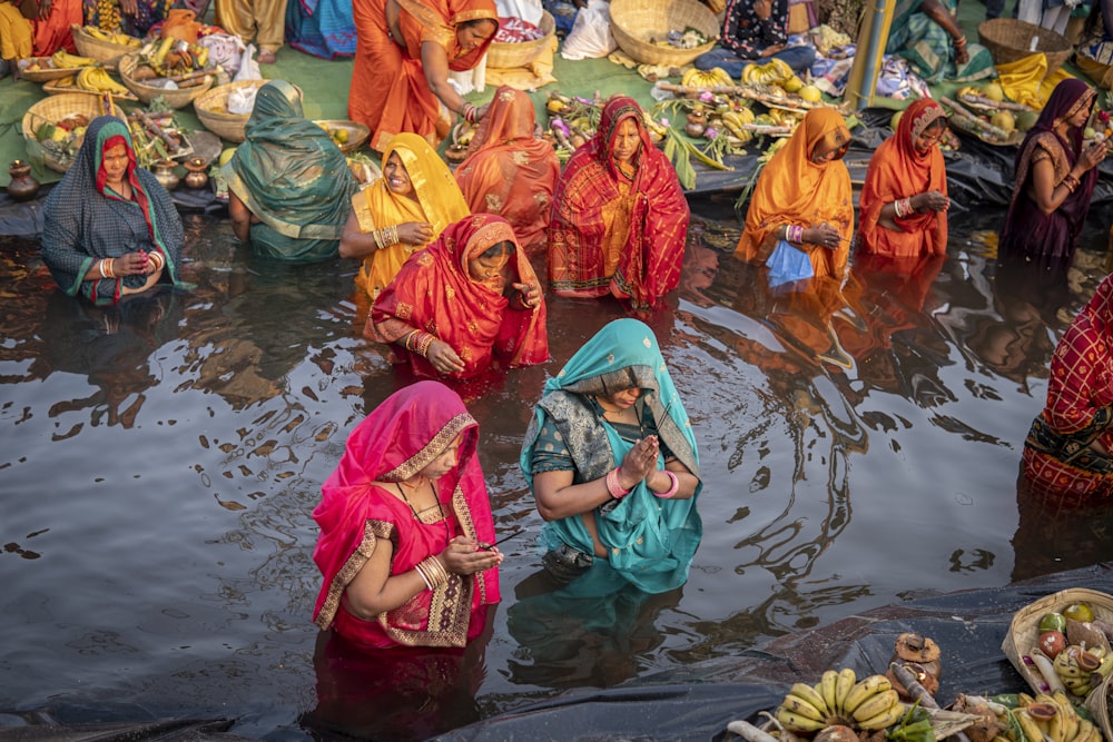 a group of women in sari bathing in a body of water