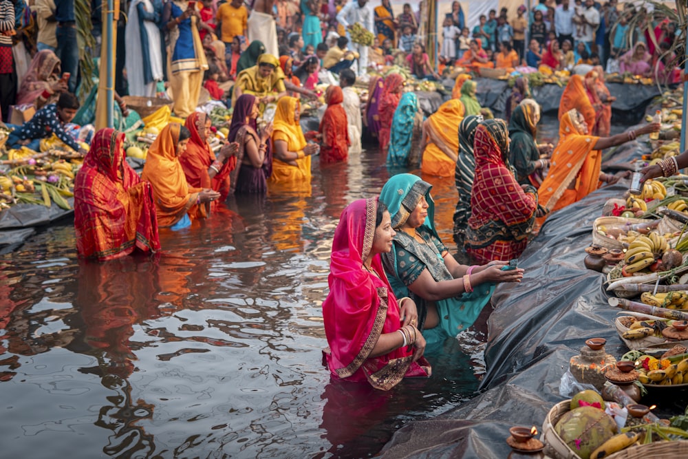 a group of women in sari bathing in a body of water