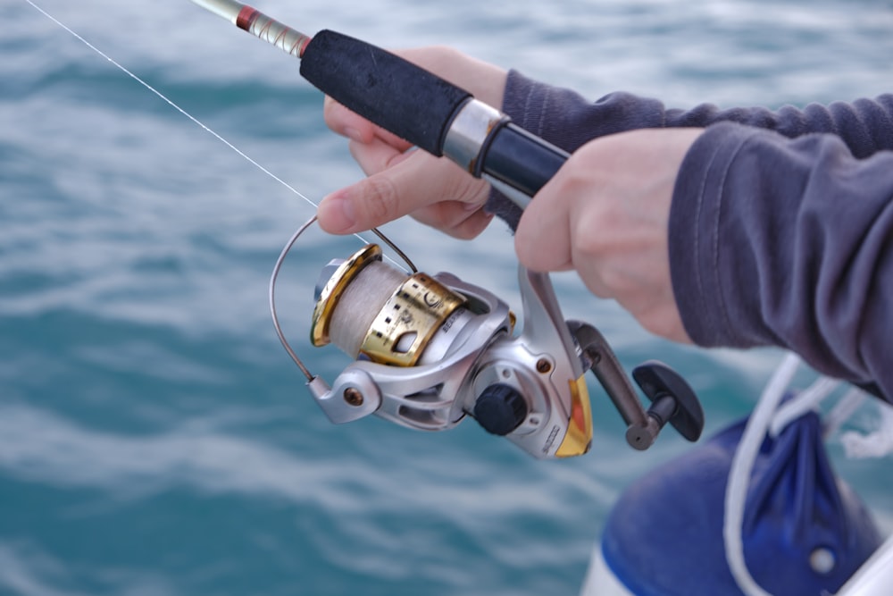 a person holding a fishing rod and a fishing reel