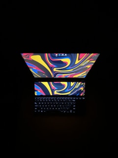 A vibrant laptop screen showing colorful funnel designs with playful animations.