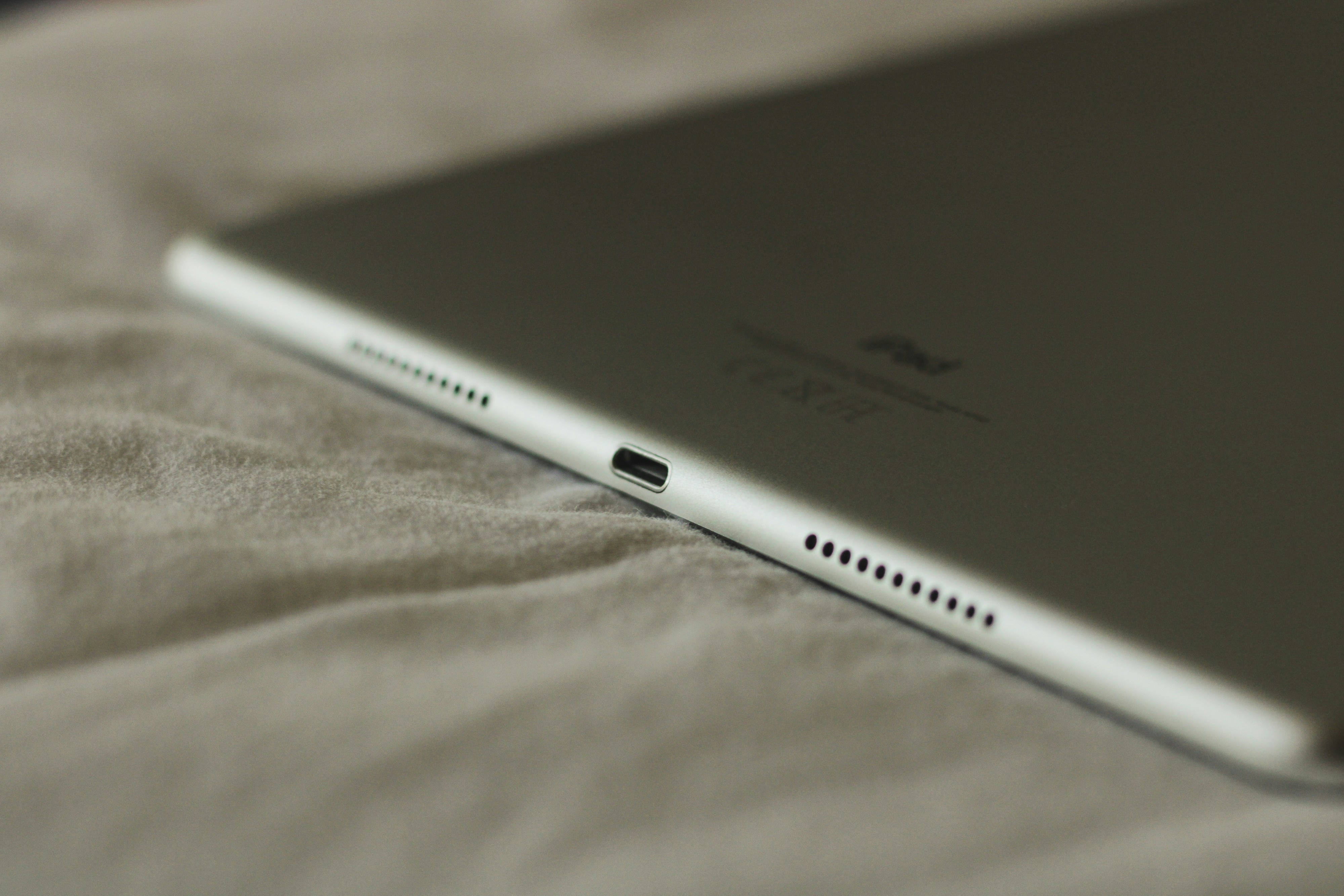 Close-up of iPad charging port and speaker grilles