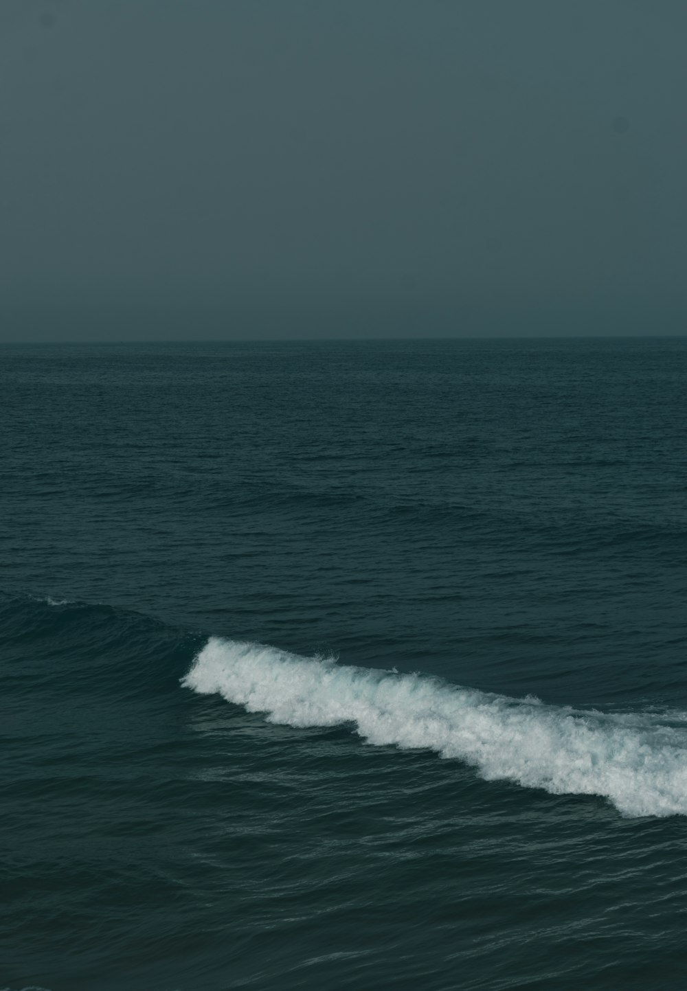 a man riding a wave on top of a surfboard