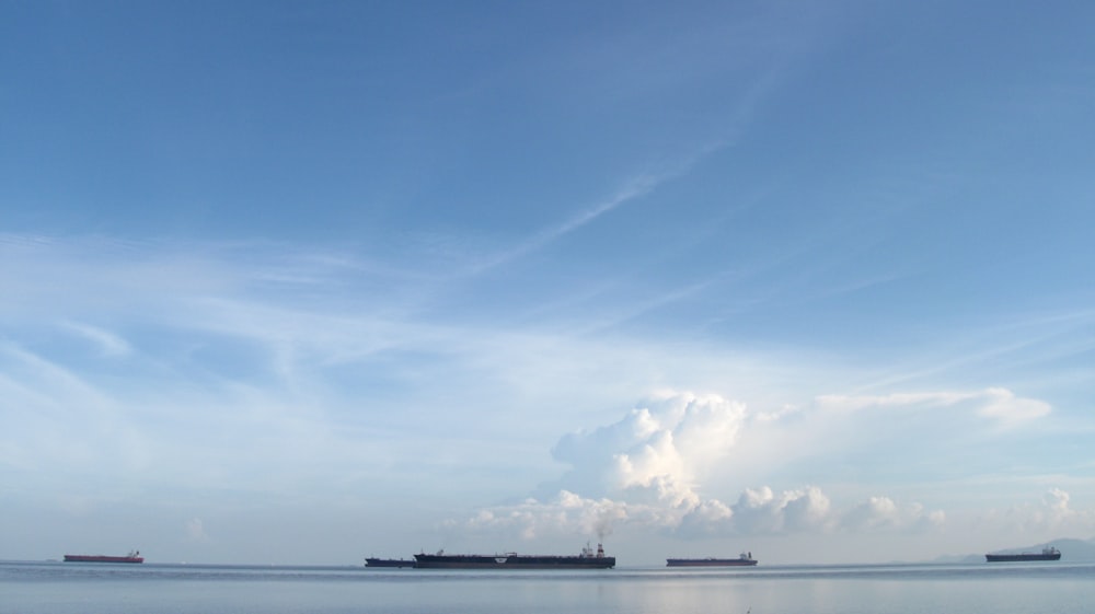 a group of ships floating on top of a large body of water