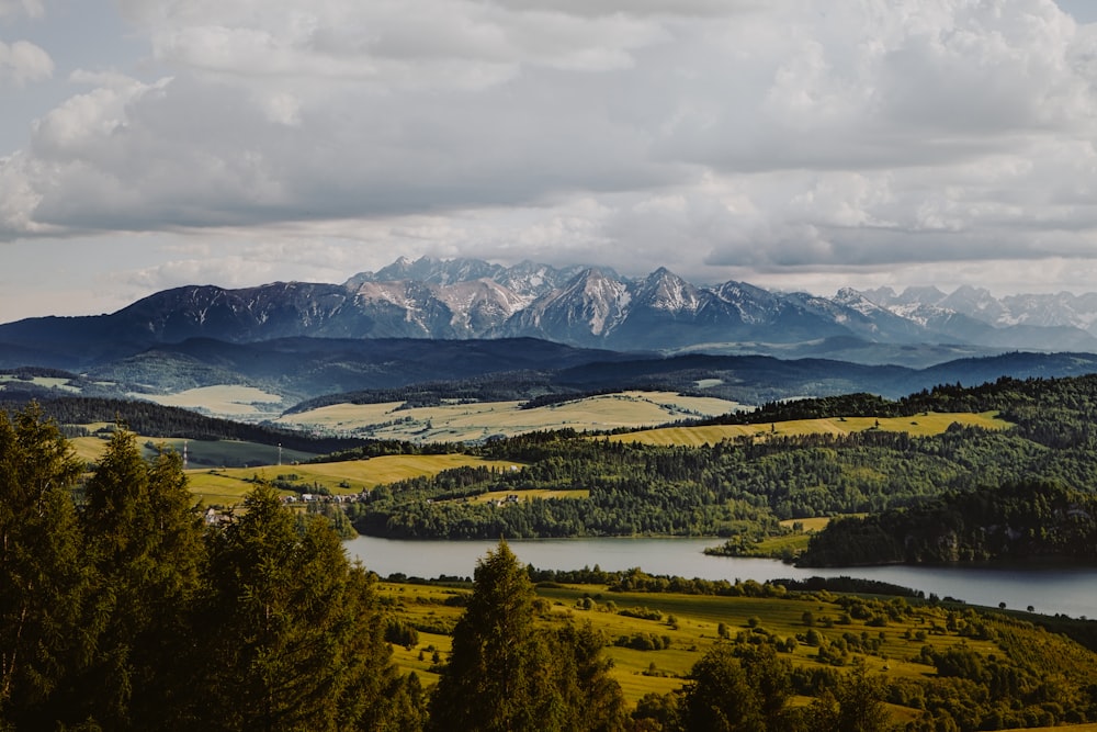 a scenic view of a mountain range with a lake in the foreground