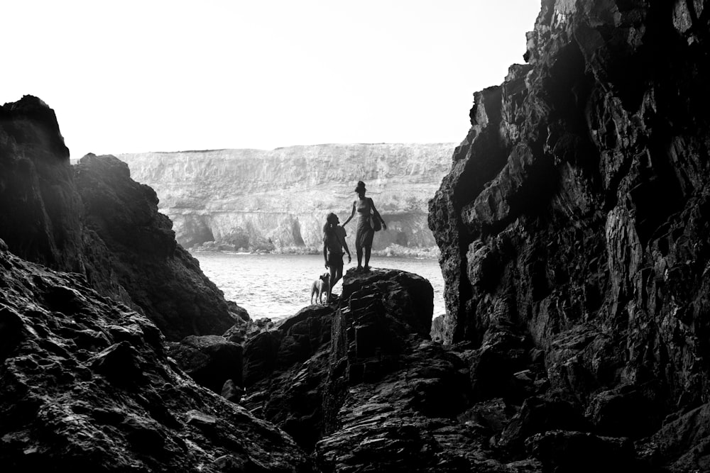 a couple of people that are standing on some rocks